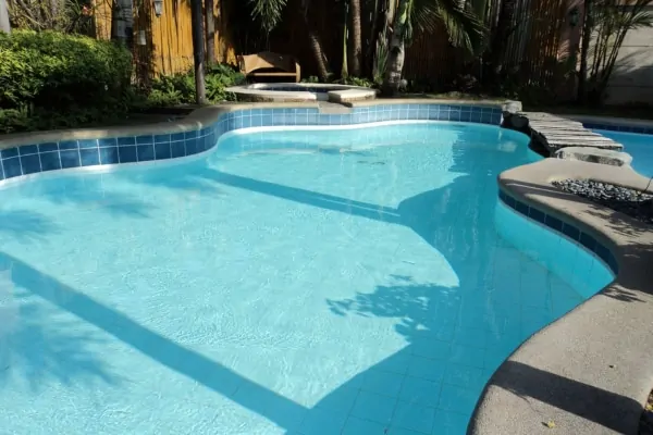 Inground pool and attached spa finished with natural stone coping and pool deck
