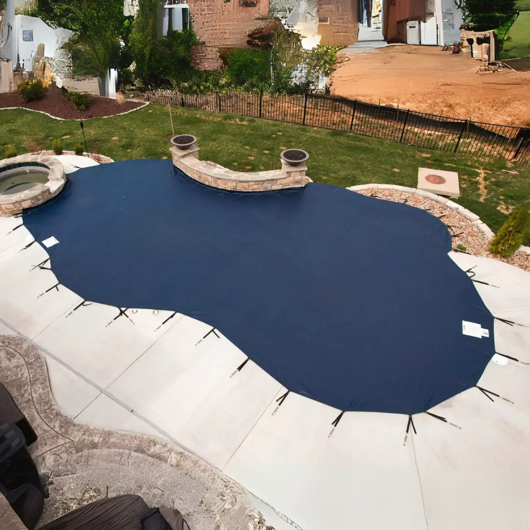 Inground pool under a winter safety cover during a seasonal pool closing in Westchester