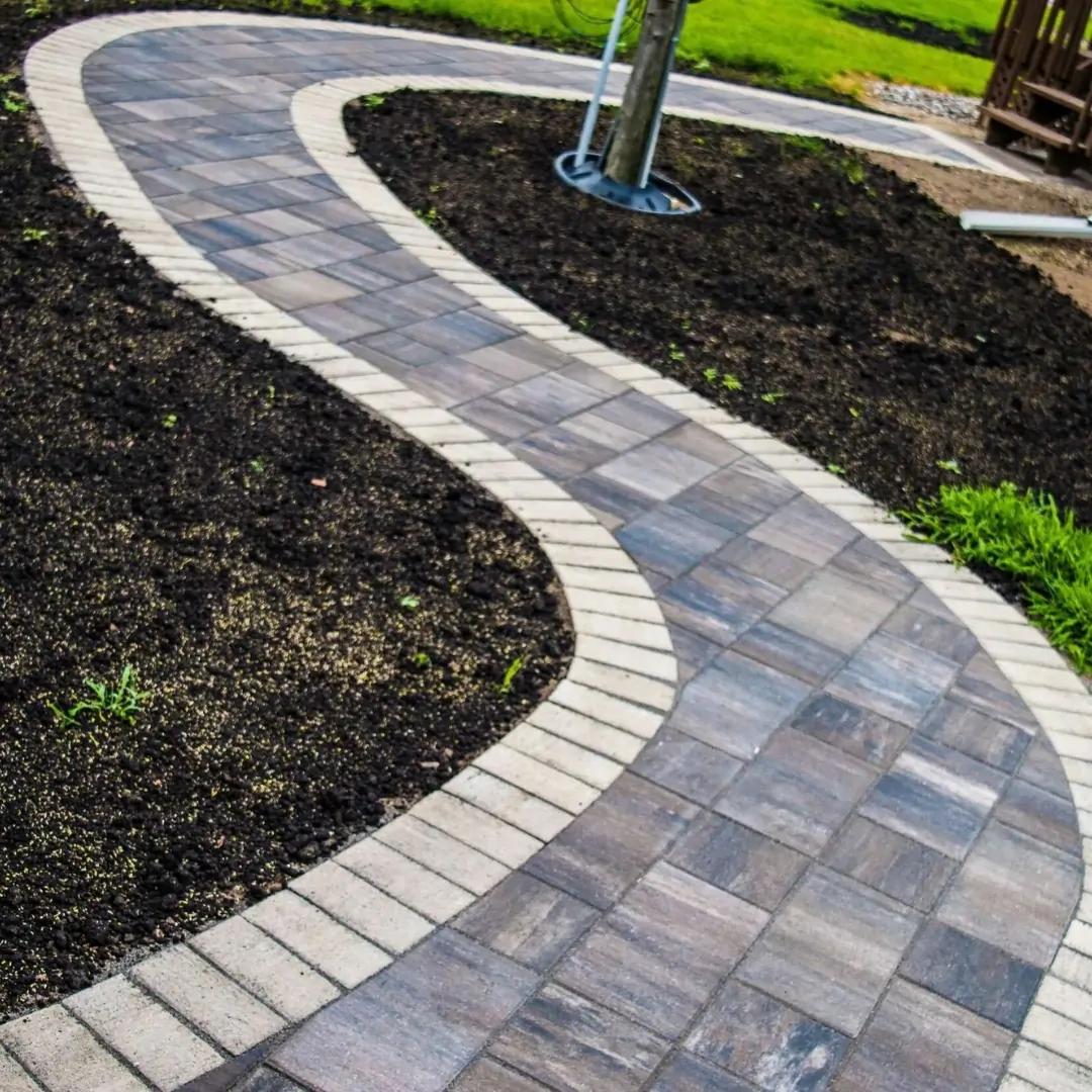 Curved paver walkway laid through a landscaped garden bed by Angel's Pools